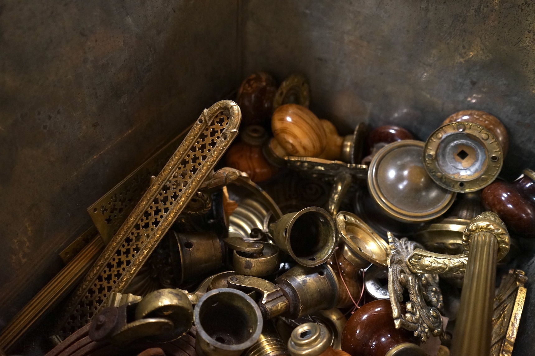 An Anglepoise lamp and metal door furniture and fittings in a tin trunk